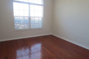 Front bedroom with large window and hardwood floor