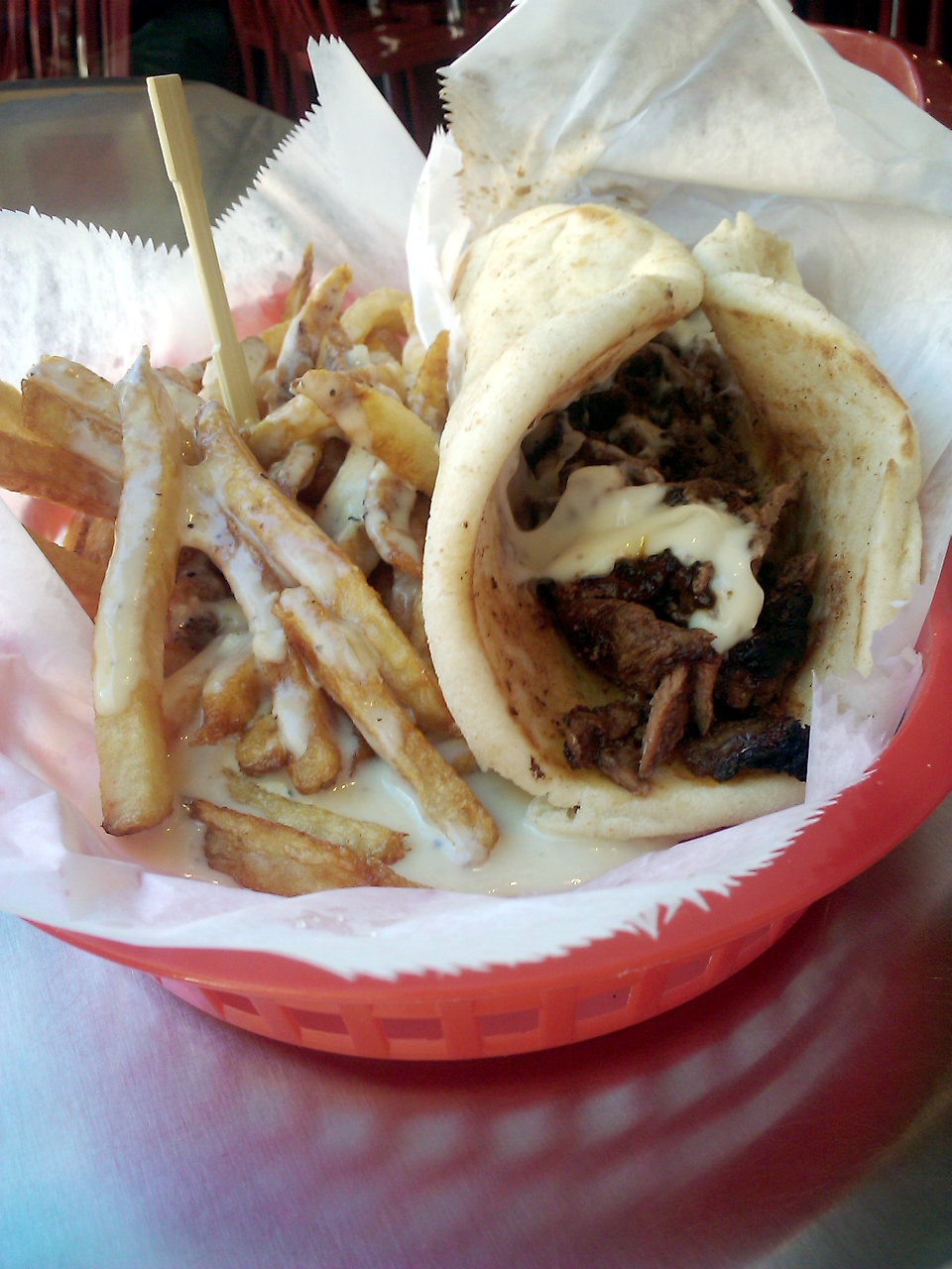 A basket of beef shawarma and fries with pepper gravy and cheese sauce..