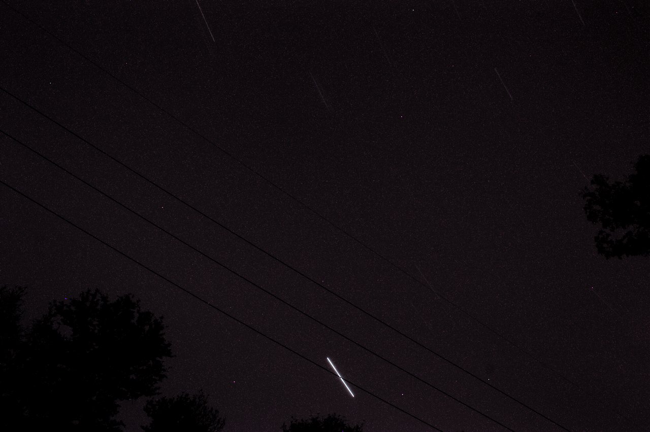 Star trails from a 20 minute exposure with some trees and power lines in the foreground.  