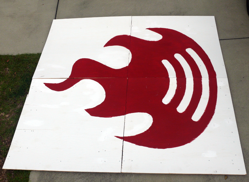 BarcampCHS BFS (Big F-in Sign) made from two sheets of 4'x8'x1/4" plywood.  A large red BarcampCHS fireball logo is painted on the sign.