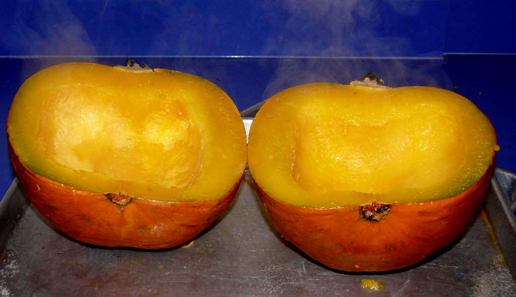 Roasted pumpkin halves with the cut side up.