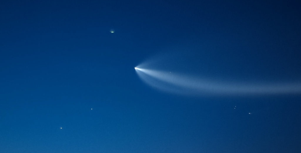 Falcon 9 second stage rocket.  Visible in the lower right are the two fairing halves and the first stage booster.  Venus and Jupiter are toward the lower left.