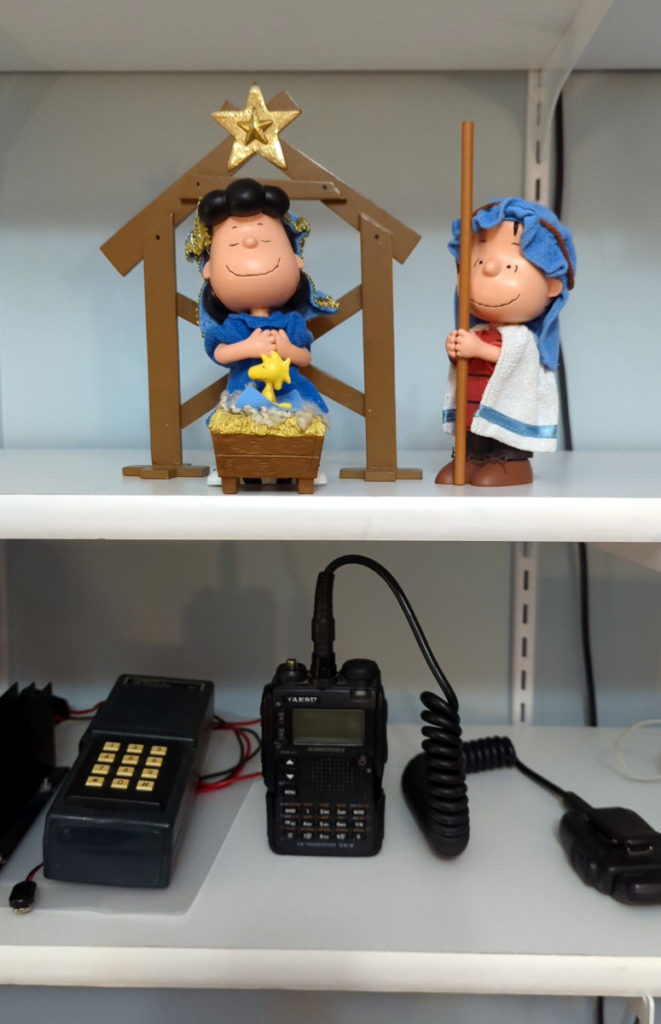 Linus, Lucy, and Woodstock on the shelf with two radios on another shelf below.