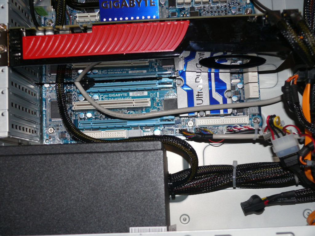 Inside the lower half of the computer showing the motherboard, video card and power supply